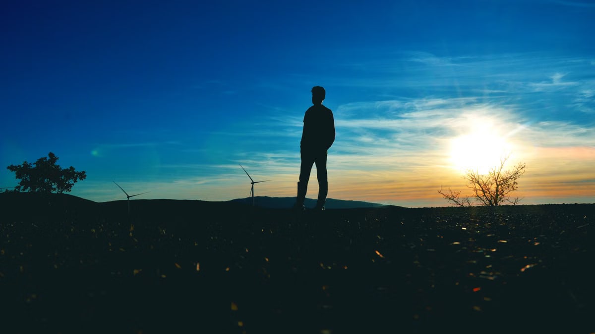 Silhouette of a person against a sunset sky in Tomislavgrad, Bosnia. Peaceful and captivating scenery.